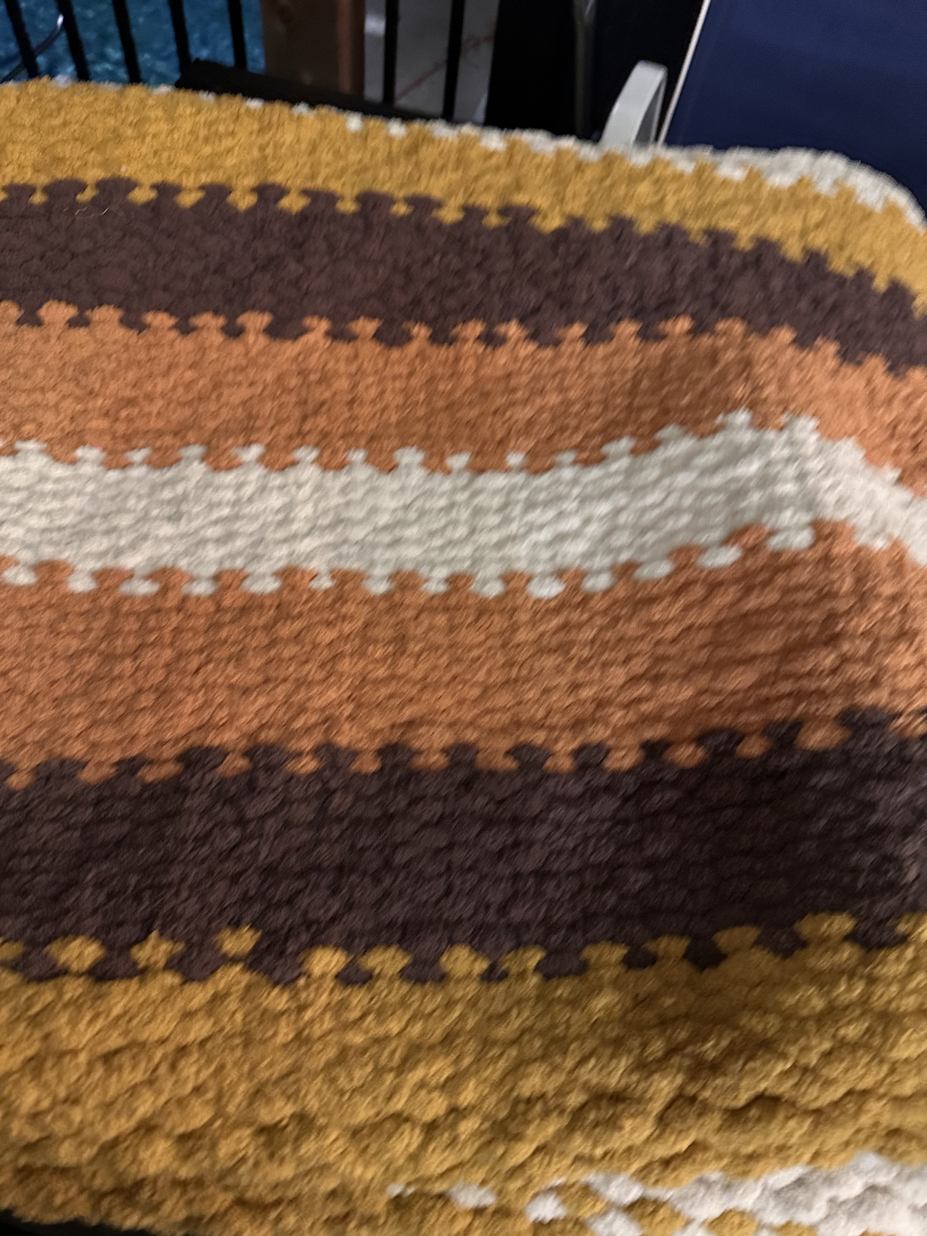 Yellow, brown, orange, and cream striped chunky knit blanket spread flat