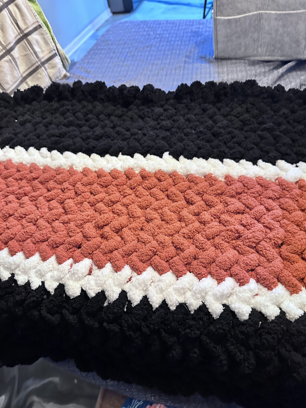 Black, white, and burnt orange striped chunky knit blanket