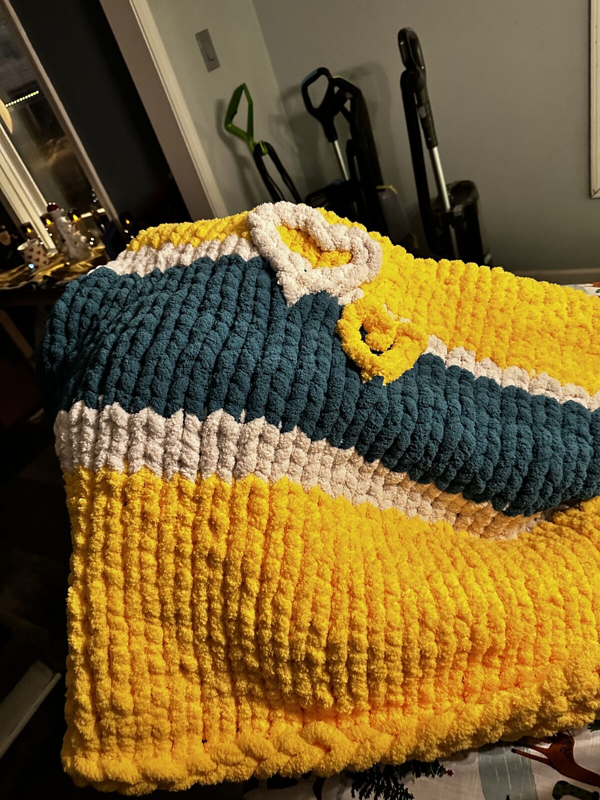Yellow, teal, and white chunky knit blanket in school colors