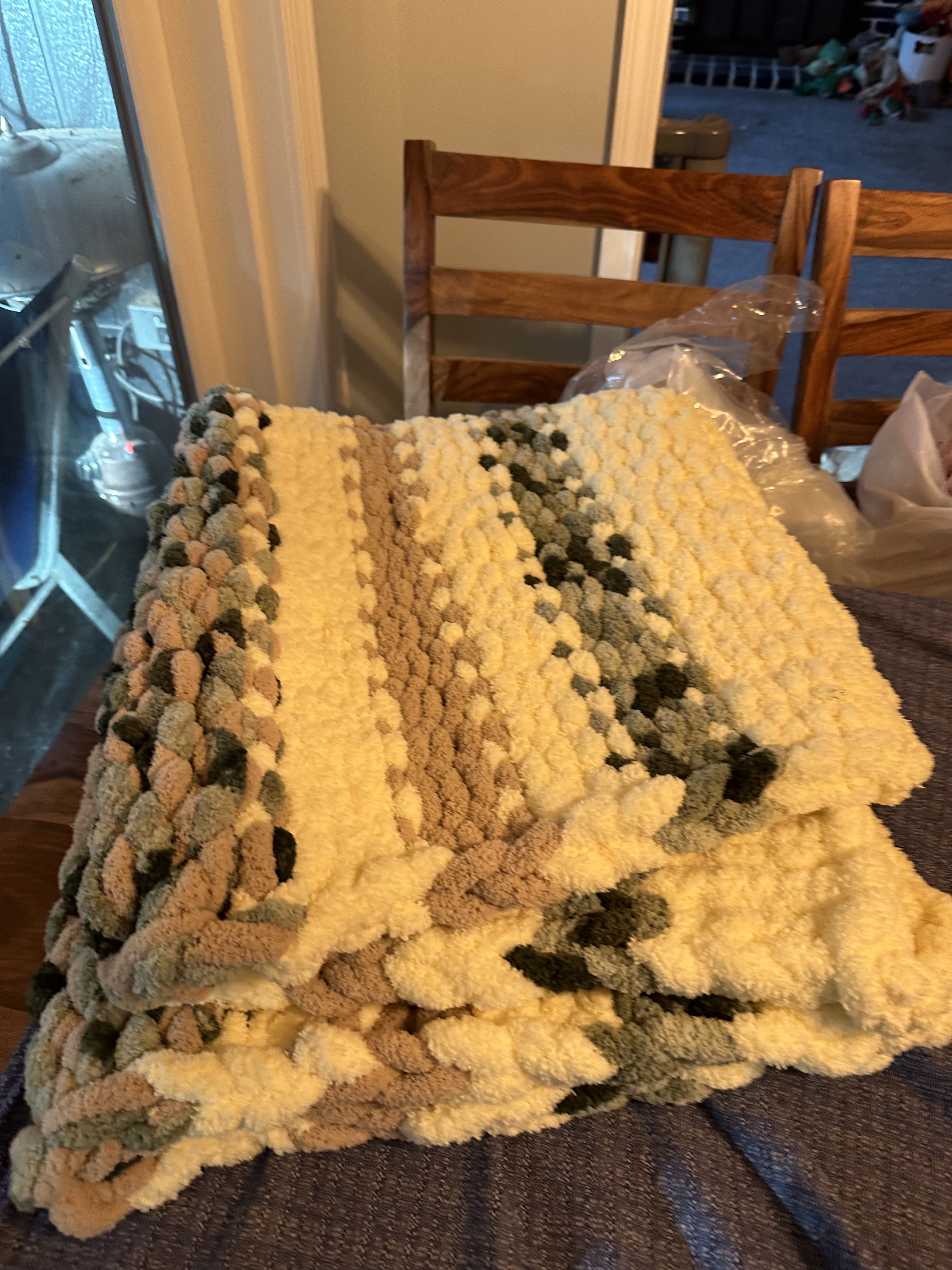 Cream, tan, and sage green chunky knit blanket